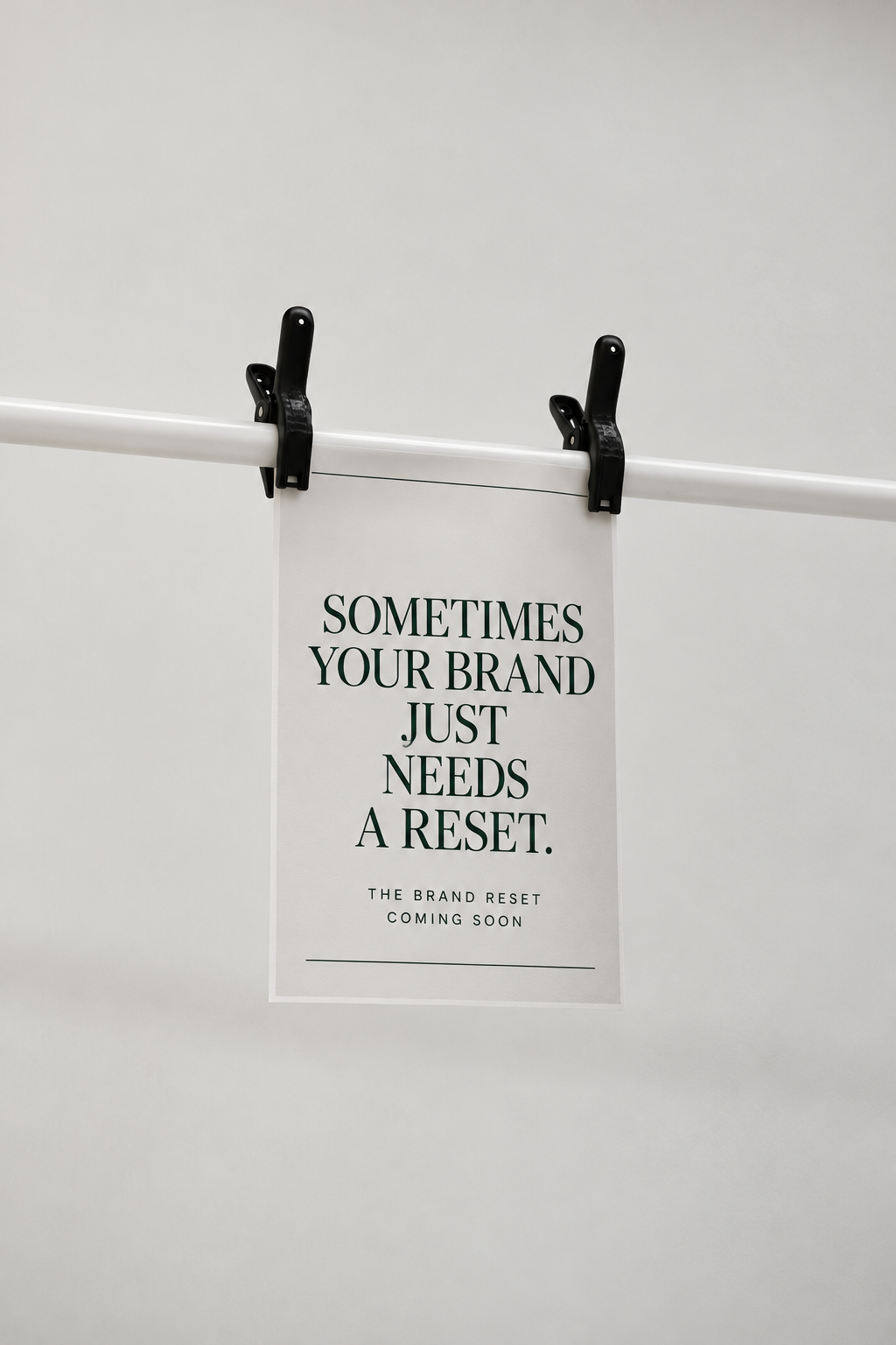 Minimal Brand Reset poster clipped to a white rail