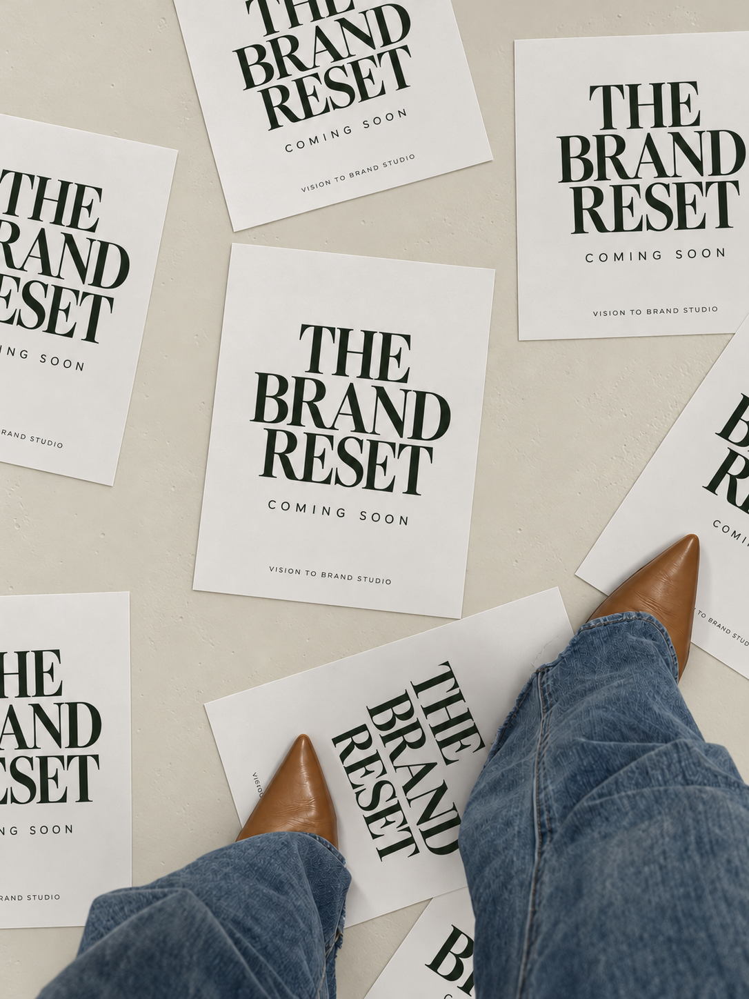 Brand Reset posters arranged on warm ivory concrete with dark green serif typography
